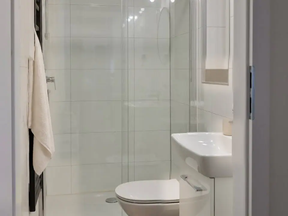 Bad des Modulhauses TINY-MAX 59 mit Dusche hinter Glasschiebetür, WC und Waschtisch. Visualisierung